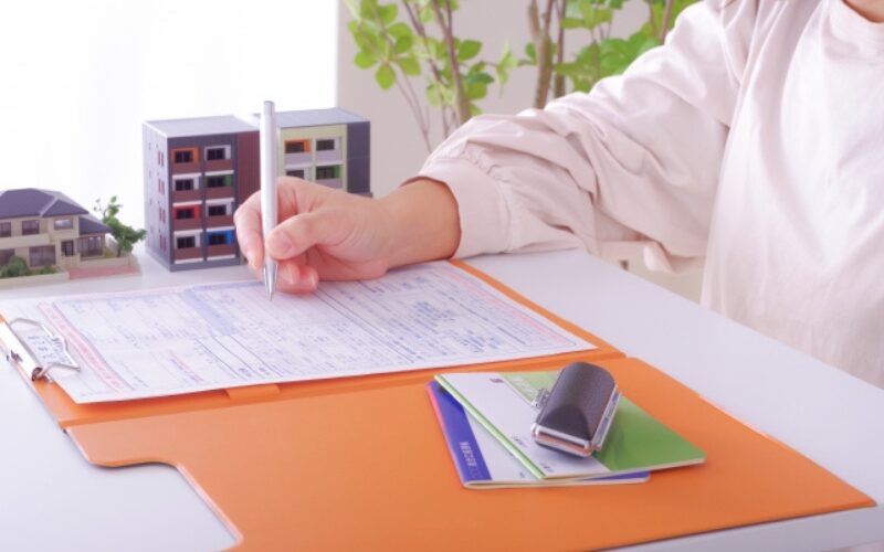 不動産売買契約の流れで、必要書類に署名・捺印を行い手付金を支払う場面