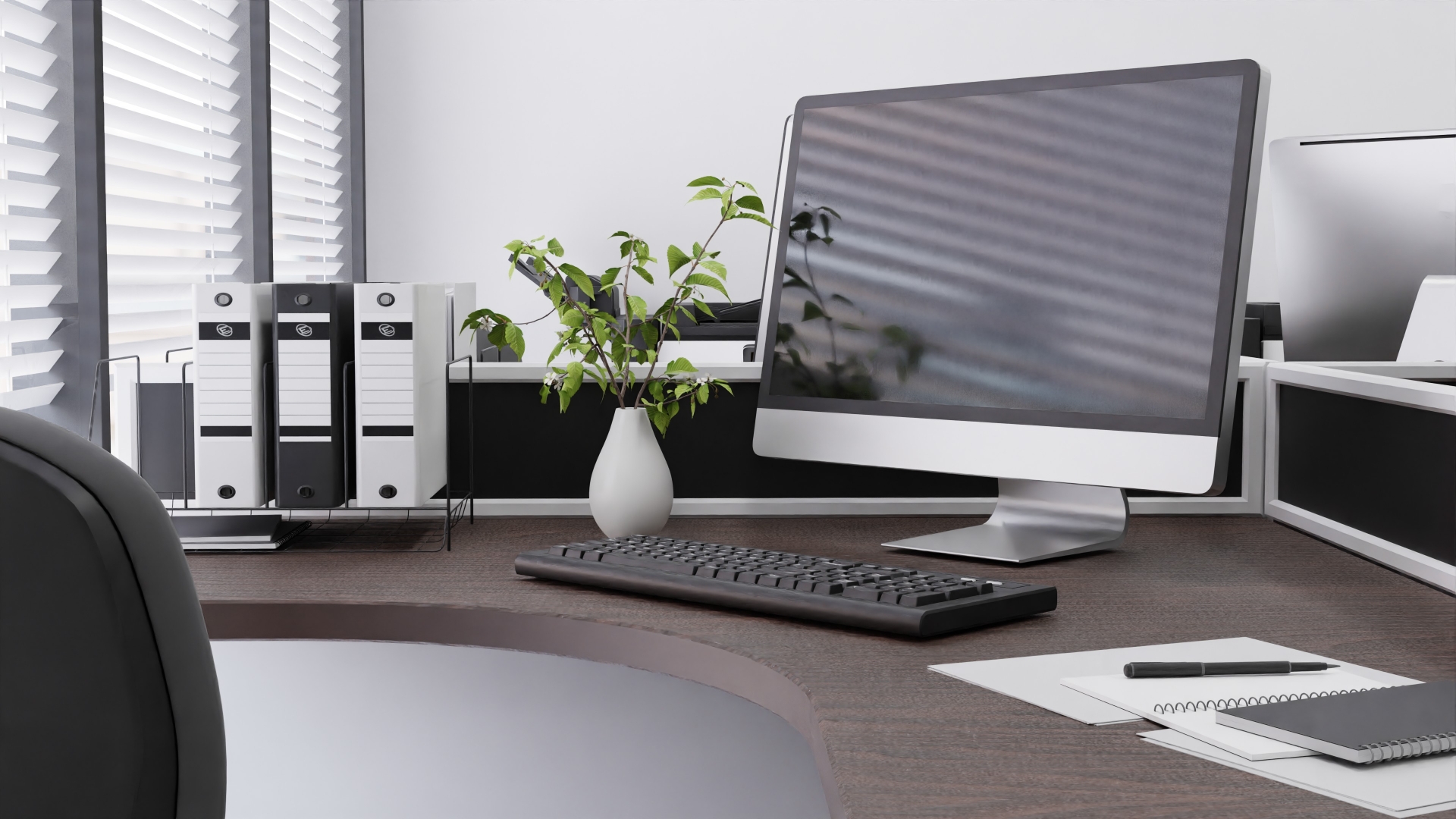 ブラインド越しのオフィスデスクとPC