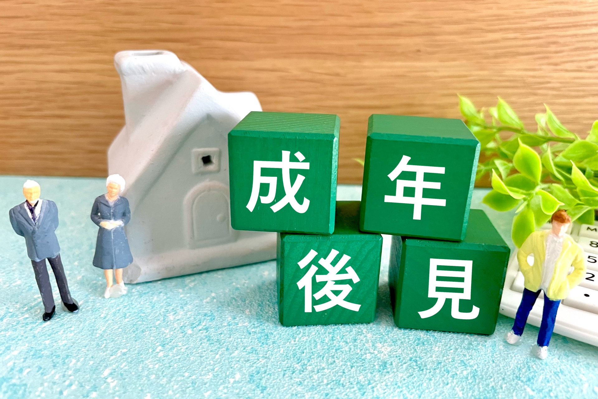 不動産売却と成年後見制度。積み木で示された成年後見の文字と住宅模型