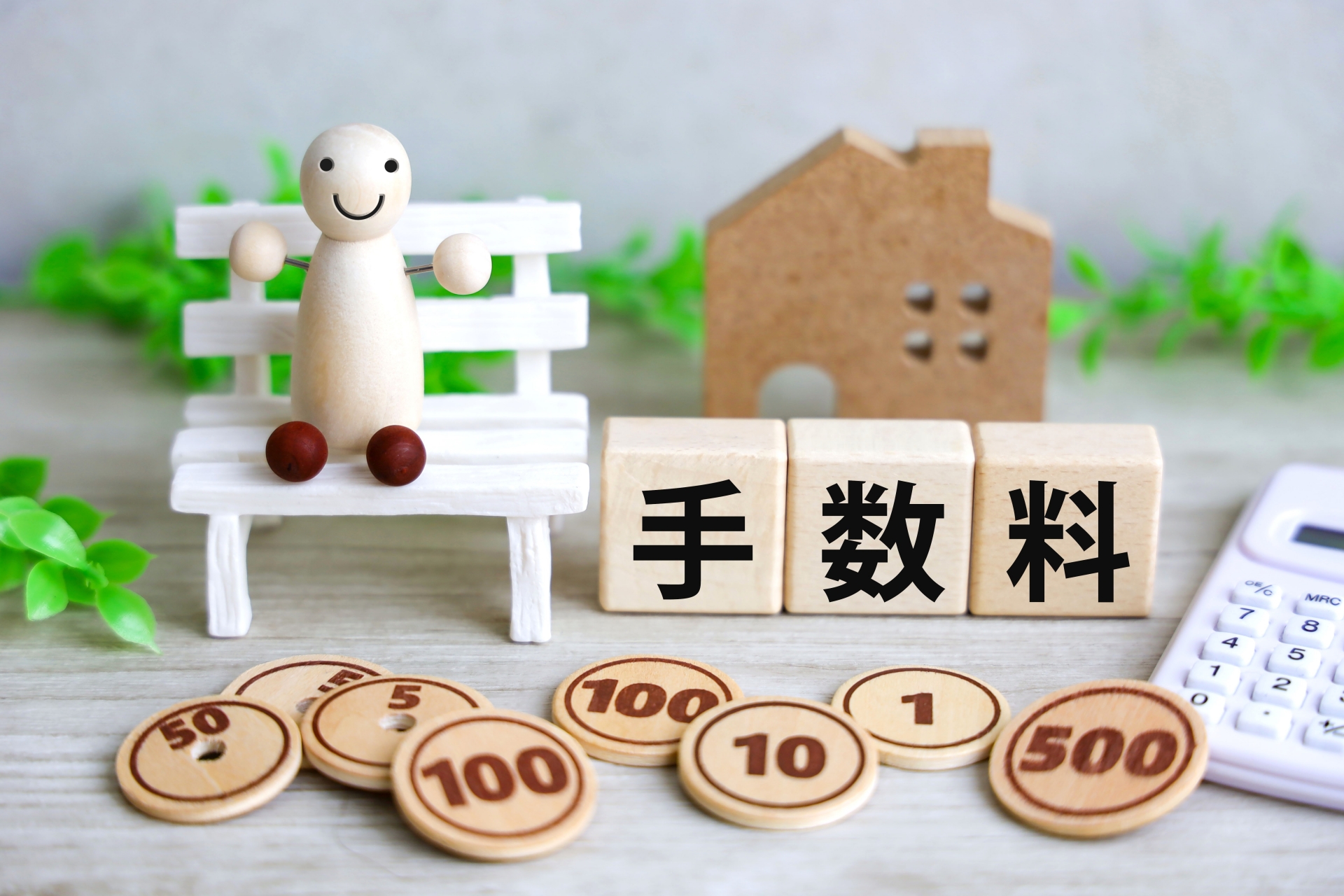 不動産売却にかかる費用、仲介手数料。手数料の文字、電卓、家の模型