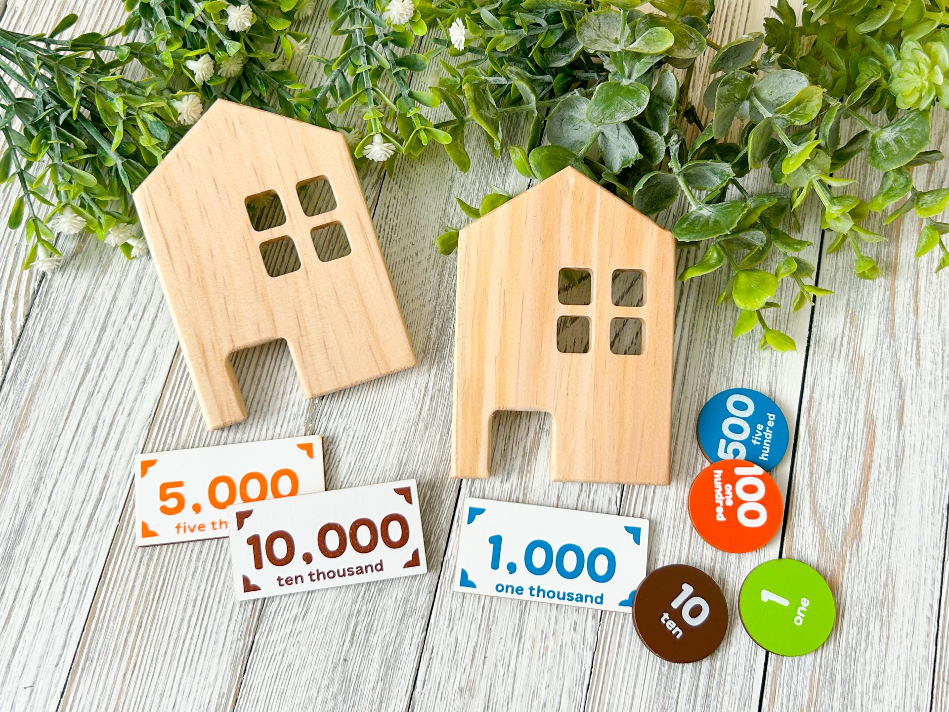 木製の家と数字の入ったコインやカード