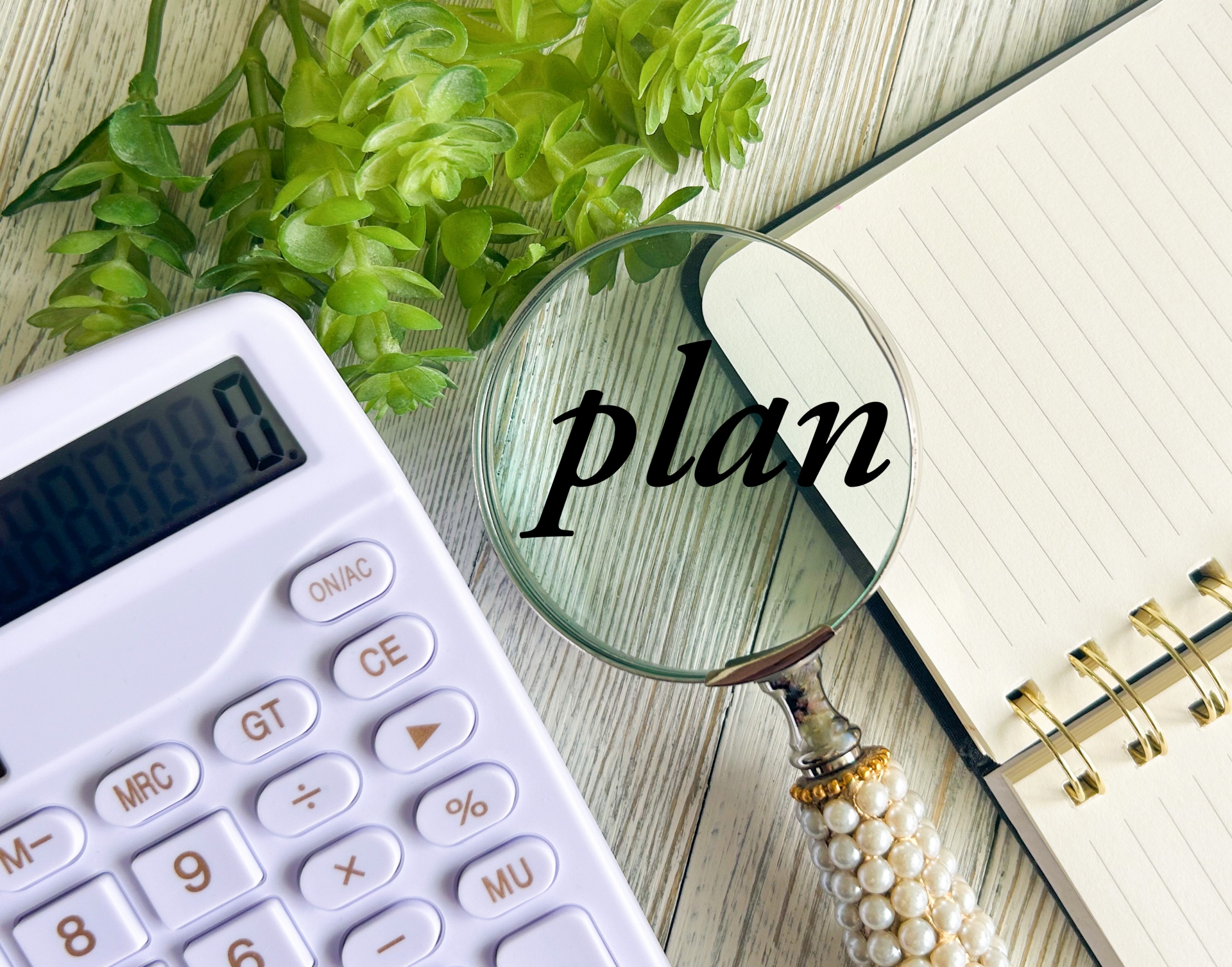 不動産売却の売却計画作成。電卓、ノート、虫眼鏡で計画性を表現