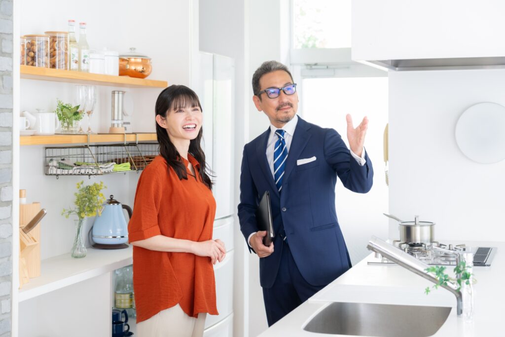 不動産会社担当者が顧客にキッチンを案内