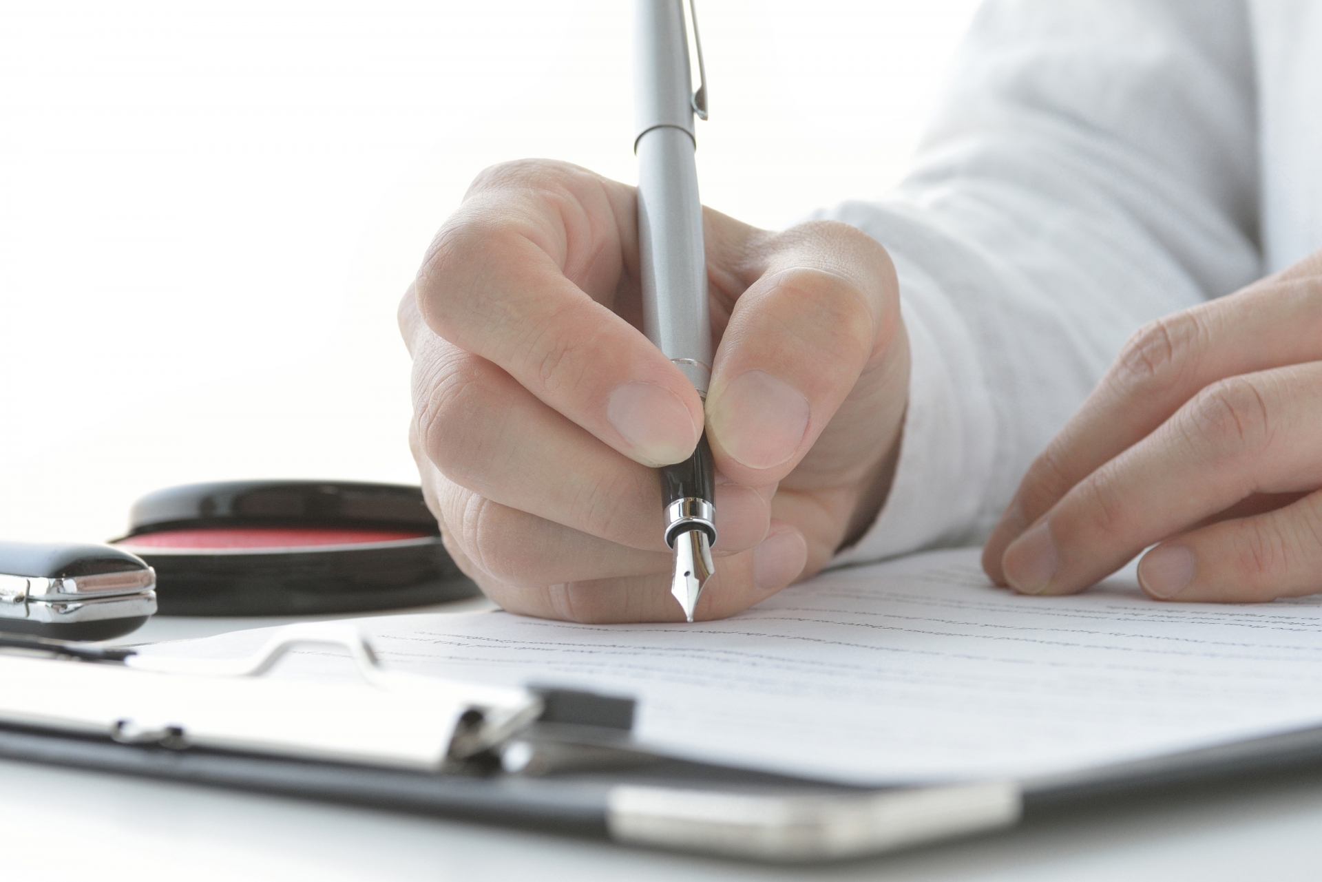 不動産売却の契約書に署名する手元