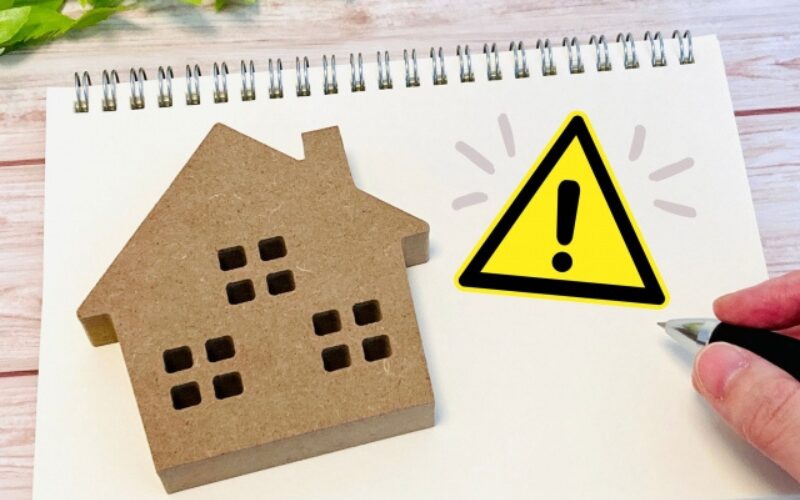 住み替えに伴う家が売れないといったリスクを、家の模型と黄色い注意マークで強調し対処法の必要性を示す