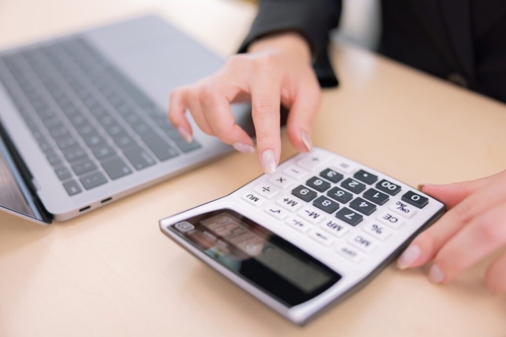 不動産売却の査定額や諸費用など、悩みや不安解消のための計算作業をする手。