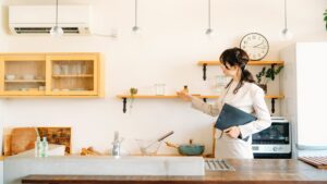 内覧を成功させるポイントとして、清潔に整頓されたキッチンを案内し説明する女性