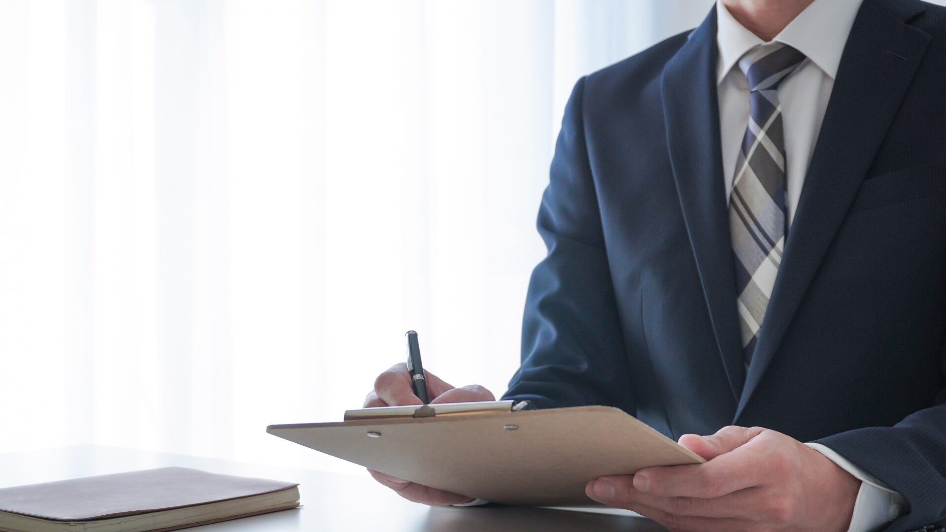 重要事項を契約書またはチェックリストに記入する担当者。不動産売却の手続きの注意点確認。