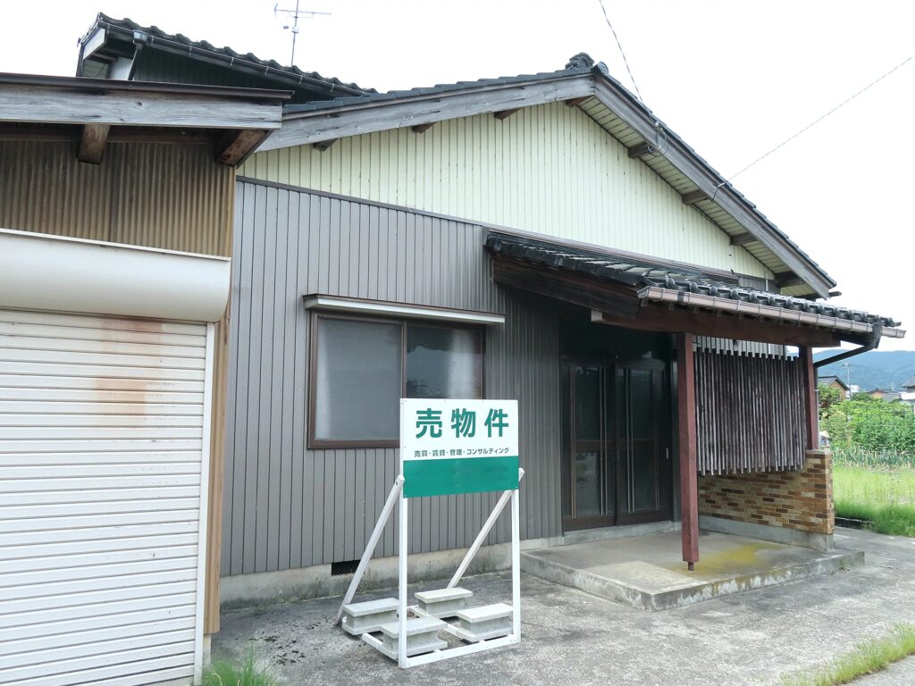 古家の実家売却を行うため、家の前に「売物件」の看板が設置された古い木造住宅