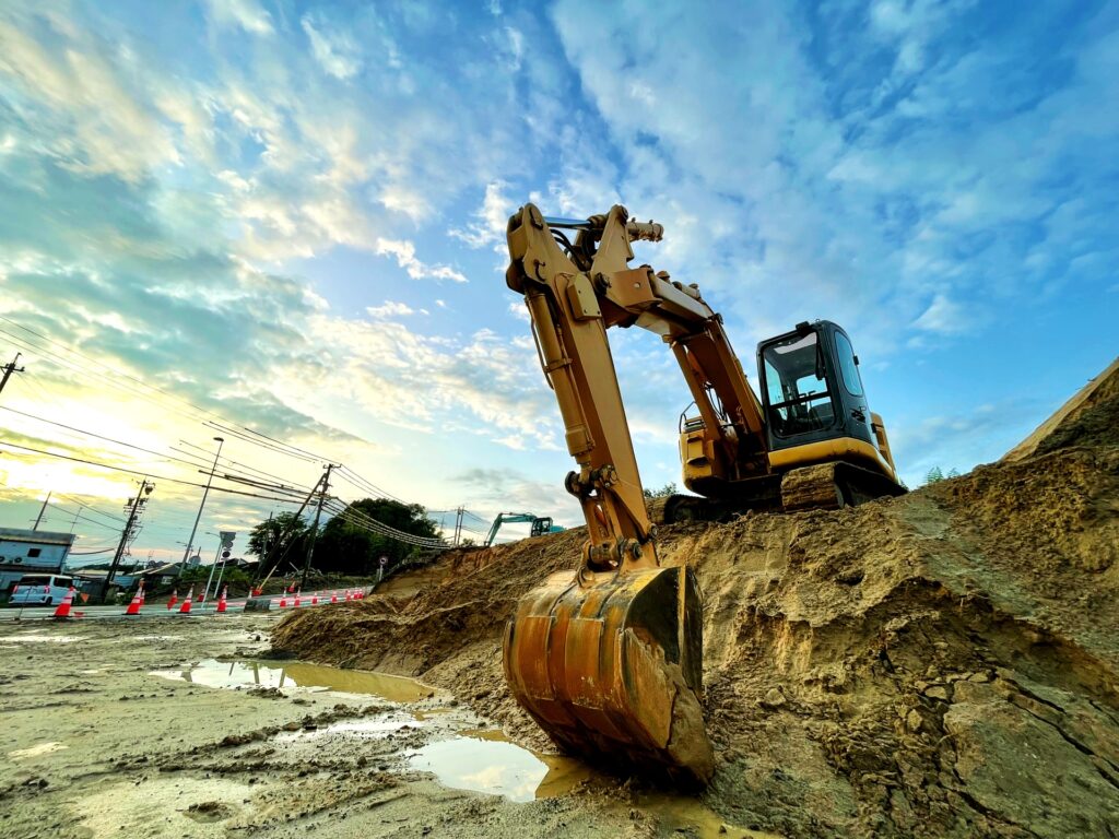 古い家を解体して更地にするオレンジ色のの重機(ショベルカー)。不動産売却前の解体作業