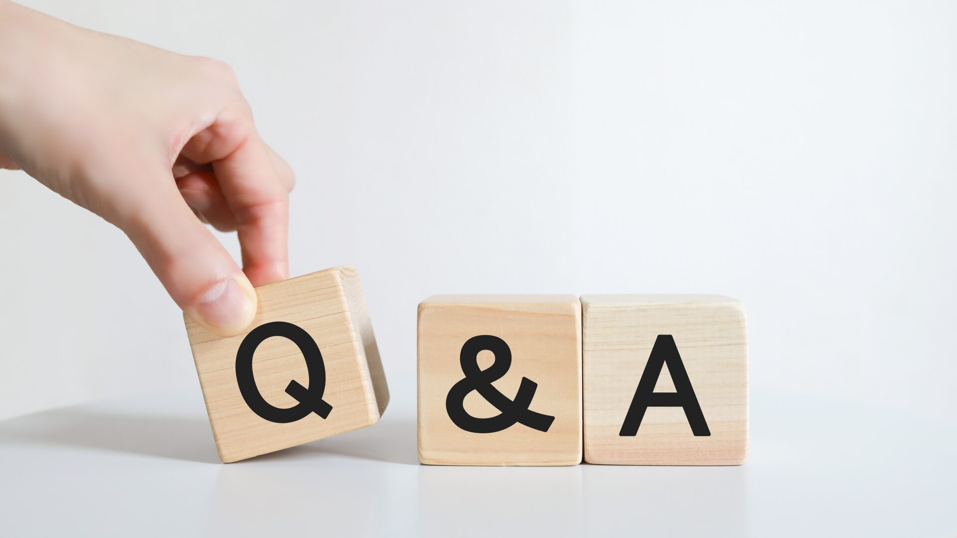 「Q&A」と書かれた木製ブロック。不動産売却でよくある質問と注意点を徹底解説。