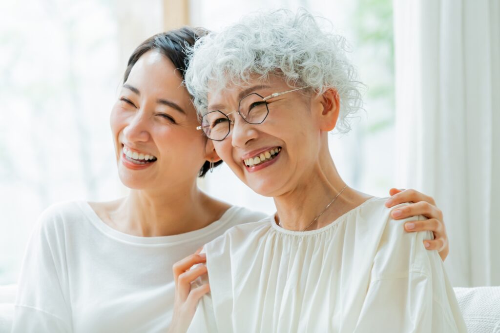 施設に入った親の介護費用や生活費を支援するために家を売却する親子の笑顔