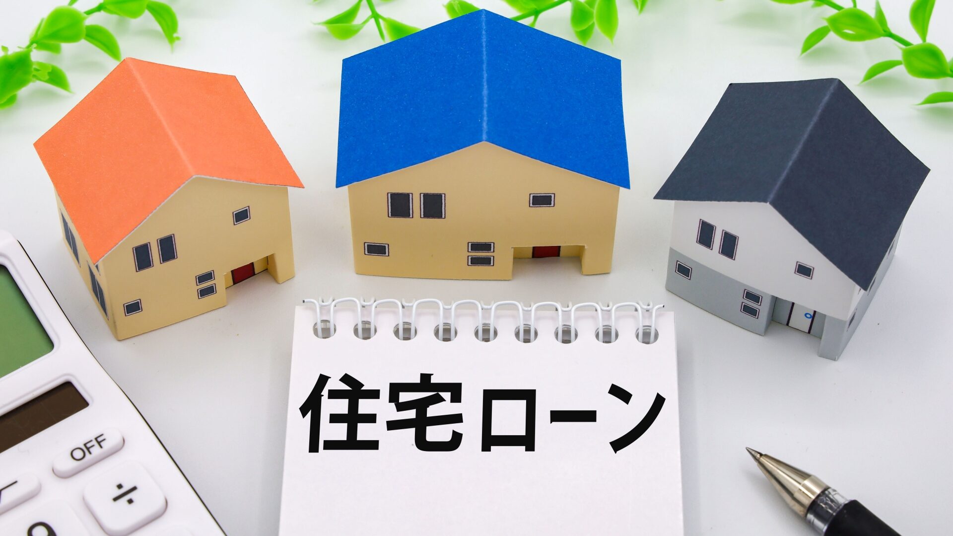 「住宅ローン」のメモと家の模型。不動産売却時の残債処理などの注意点。