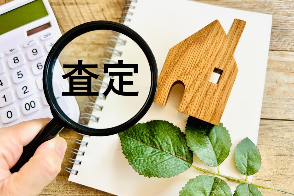 虫眼鏡で「査定」の文字を見る。空き家処分の際の売却価格の査定、不動産評価