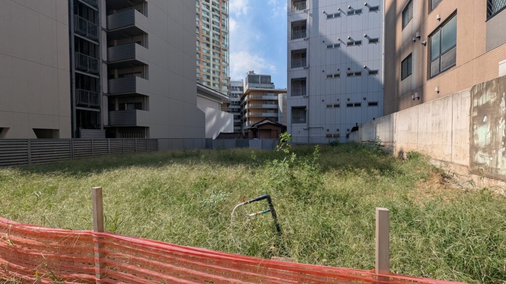 都心のビル群に囲まれた、空き家を解体処分した後の更地。土地活用や売却の検討
