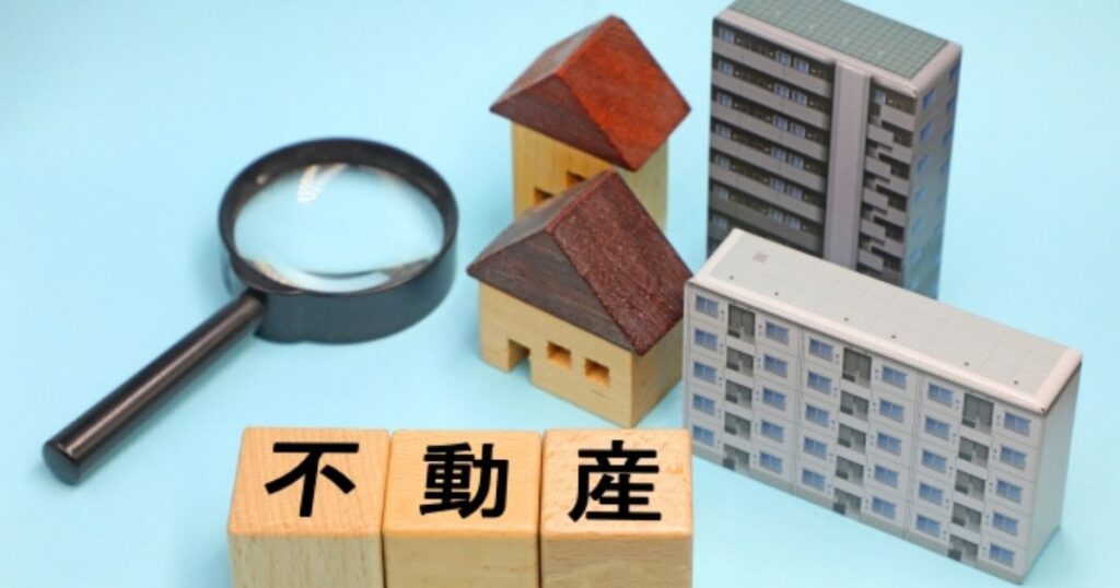 家を売る対象となる不動産という文字と戸建てやマンションの模型