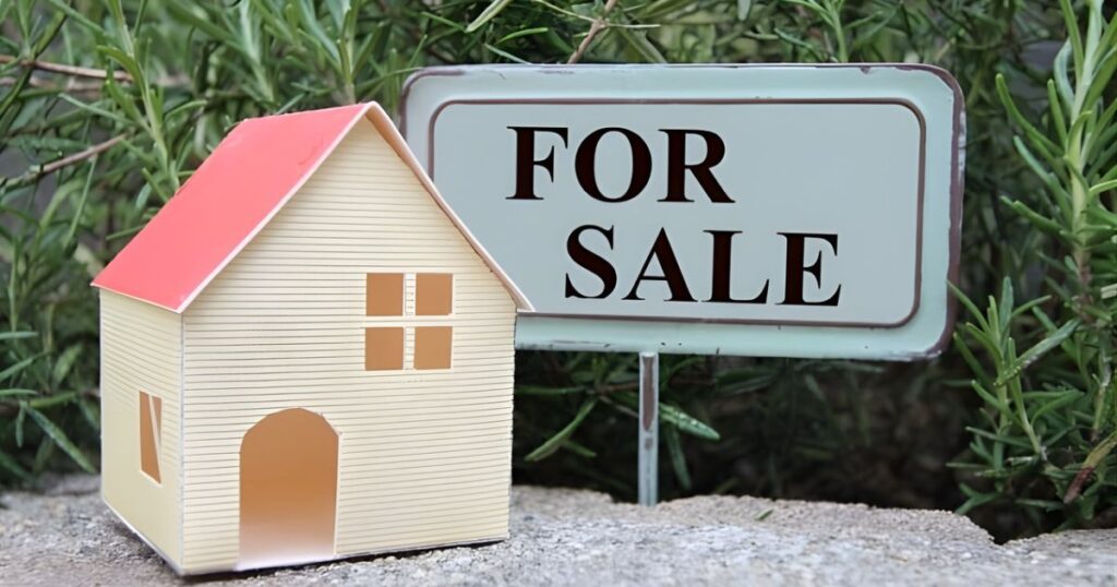 不動産売却物件であることを示す「FOR SALE」の看板と戸建て住宅の模型