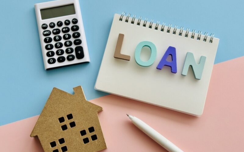 家を売る最適なタイミングを考えるために、ローン残債の確認や資金計画に必要な電卓や「LOAN」の文字