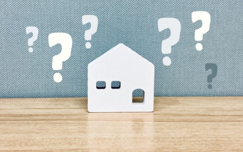 住み替えで家が売れない時の原因やに対する疑問を、白い家の模型と疑問符で表現