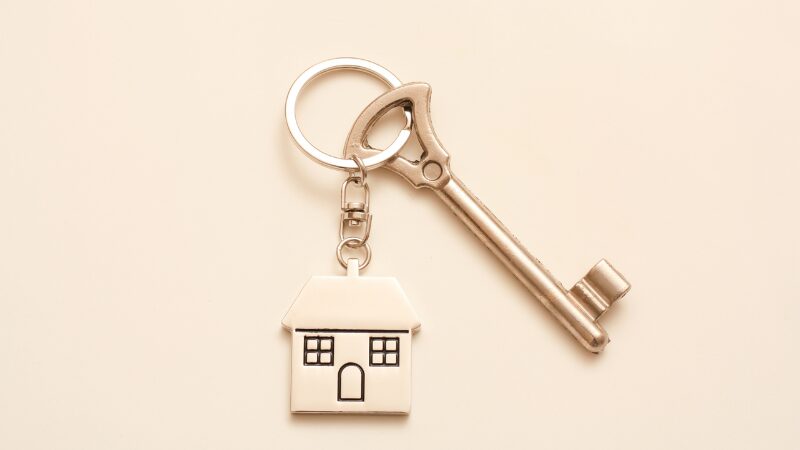 不動産の引き渡しと引き渡し後のトラブル、瑕疵責任の発生を象徴する、家型のキーホルダーと鍵