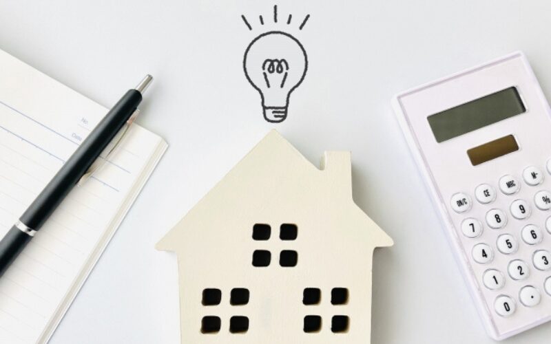 家が売れない状況を打破する事前対策のひらめきを表す、家の模型と電球のイラスト