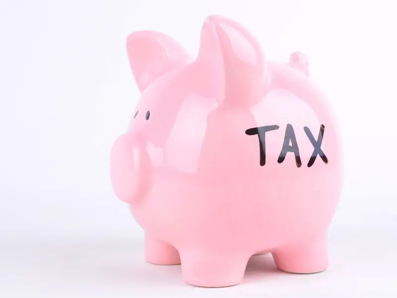 不動産売却の際に発生する譲渡所得税など、「TAX（税金）」の支払いや節税をイメージした貯金箱。