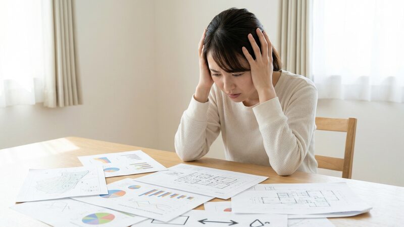 個人で土地売買を行う際、専門的な書類や多くの情報を処理しきれず不安に駆られる様子。